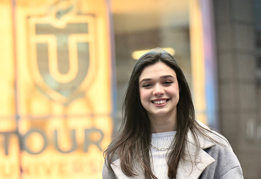 female student standing outside Touro University\'s main campus at 3 Times Square