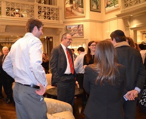 Dr. Alan Kadish (center, red tie), president and CEO of Touro College, speaks with young professionals at a cocktail reception at the home of Carol Feinberg and Ken Gilman in Manhattan.