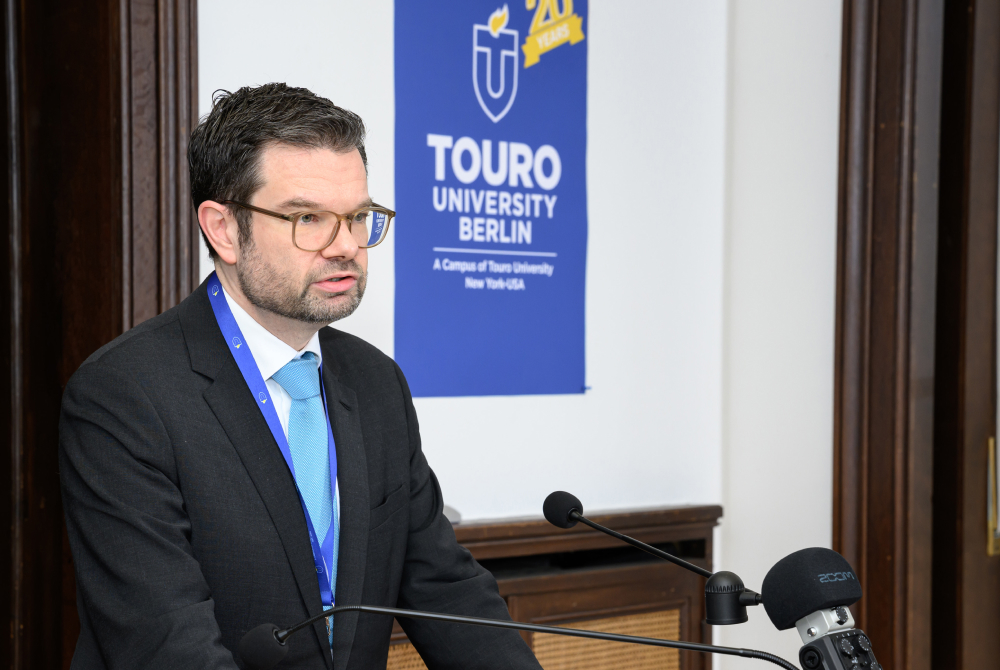 Dr. Marco Buschmann, the Federal German Minister of Justice, addresses the crowd at the special conference on antisemitism marking the 20th anniversary of Touro University Berlin.