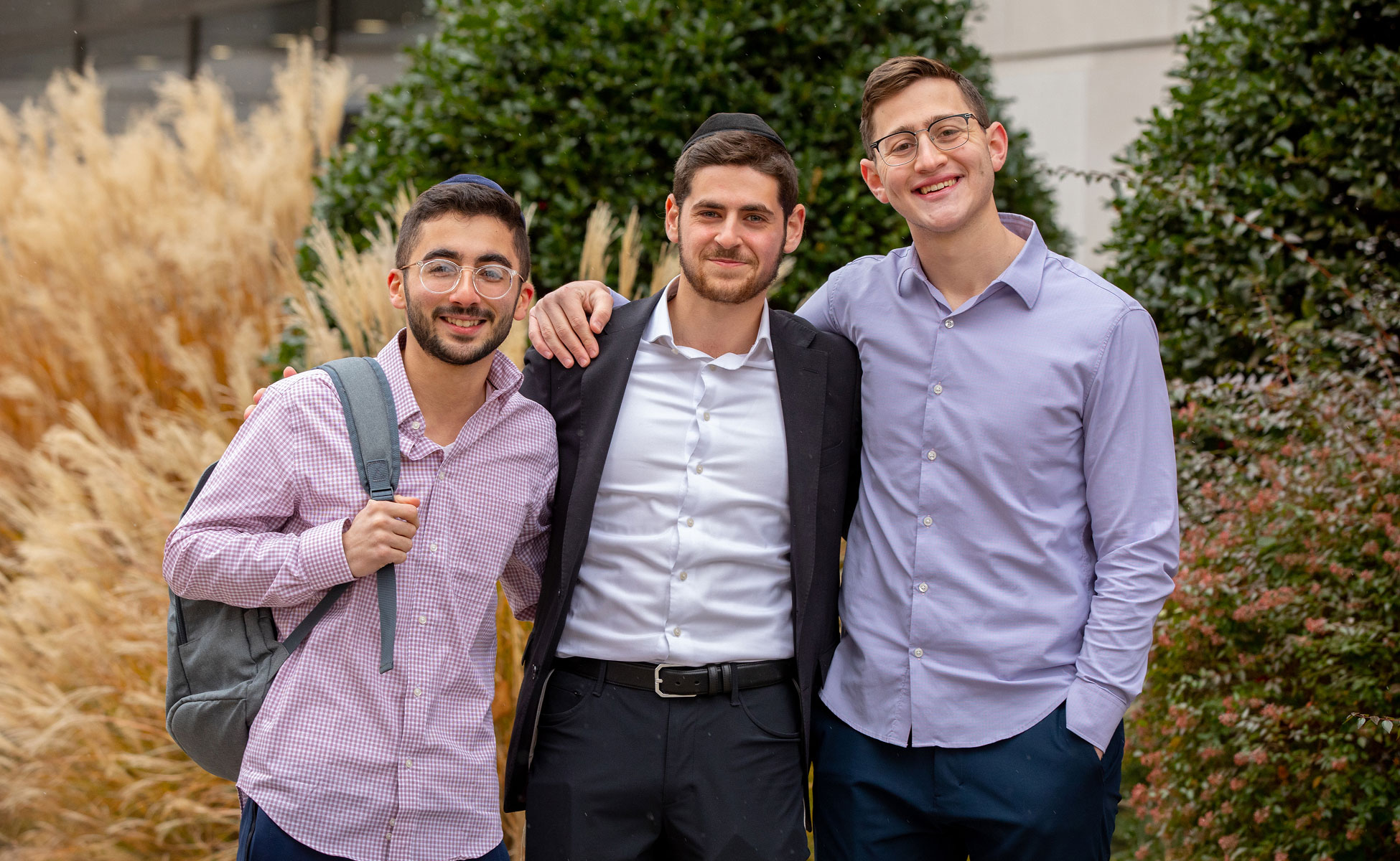 Three students smiling outside of LCM building.