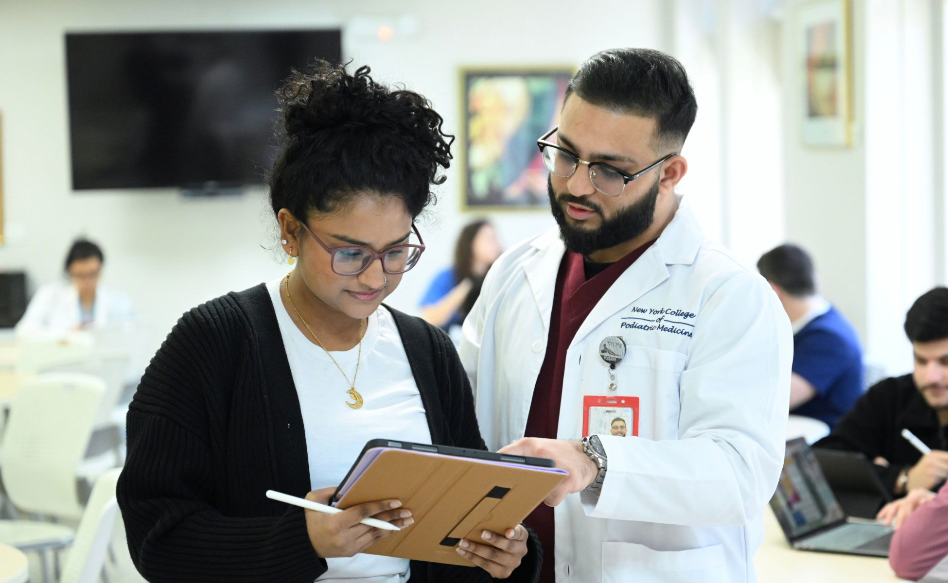 Two NYCPM students looking at an iPad