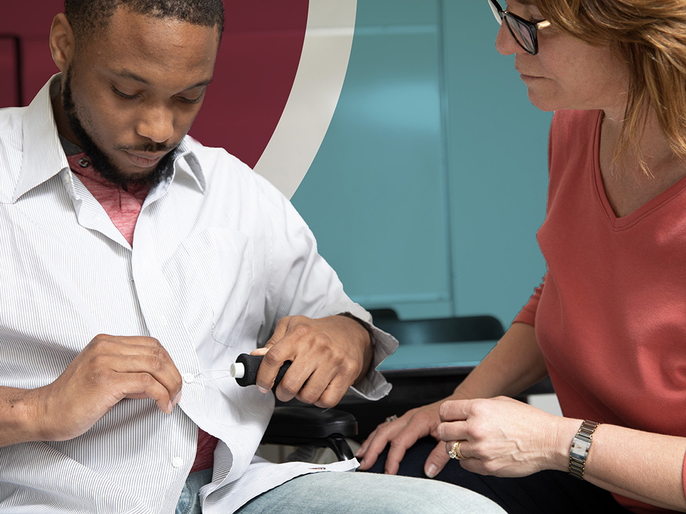 occupational therapist helping man button shirt