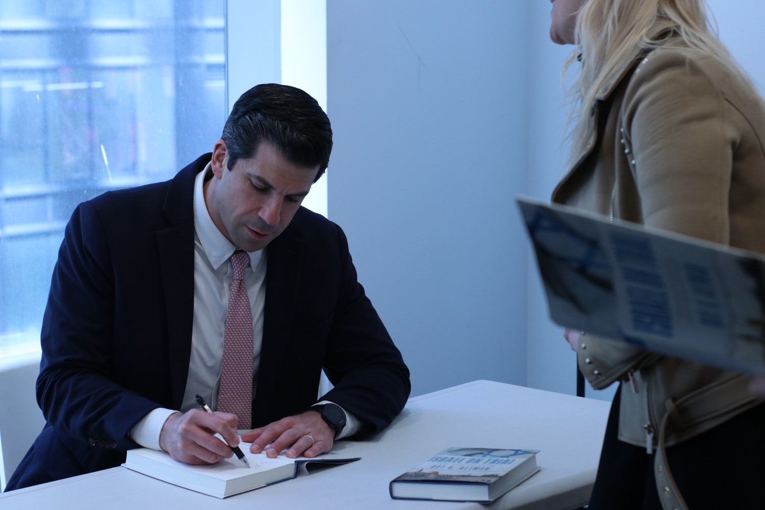 Judge Roy Altman signs a copy of his new book, Israel on Trial. 