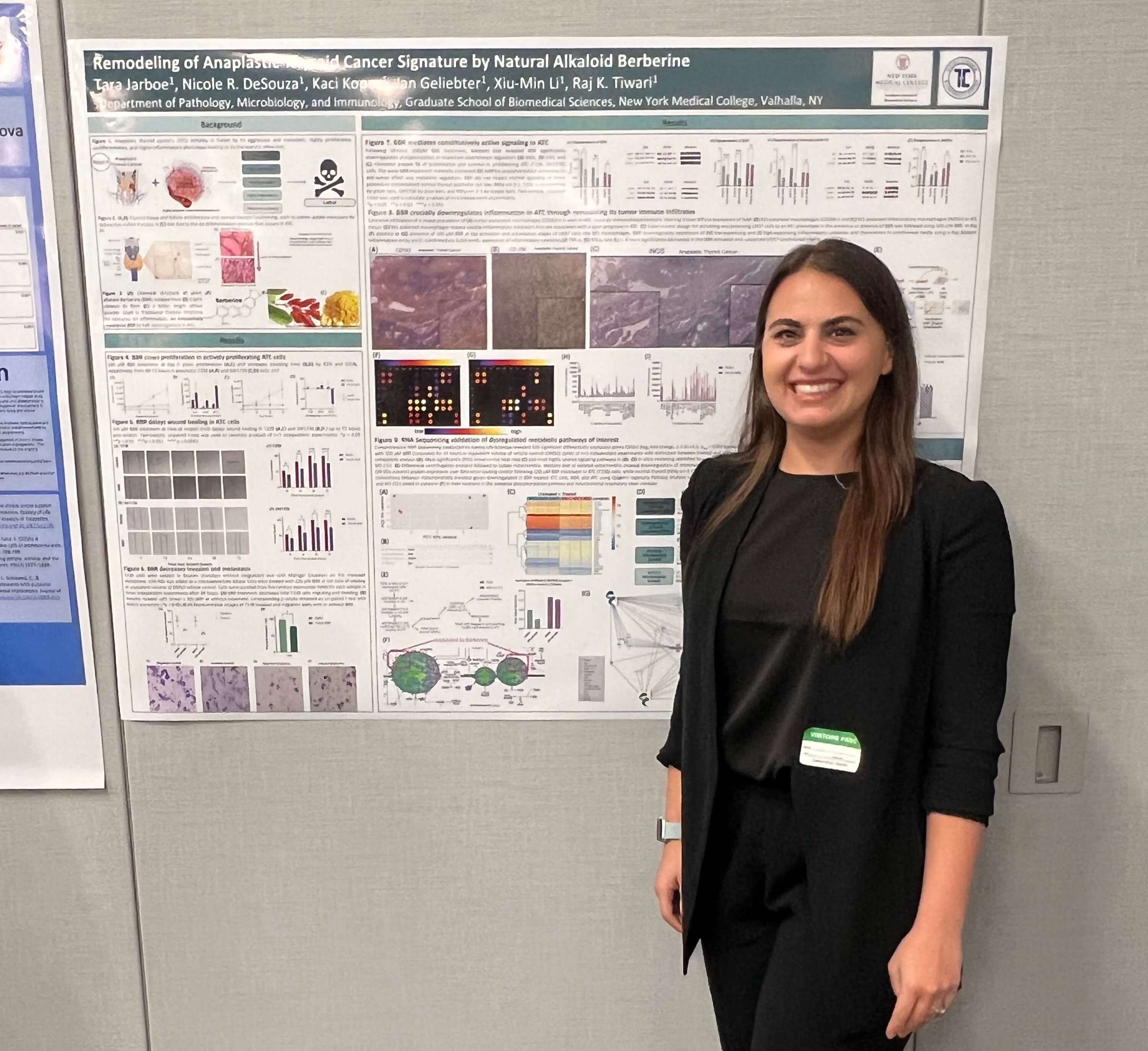 NYMC students stands in front of her research poster.