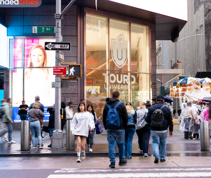 Pedestrians walk around in front of Touro University\'s campus in Times Square.