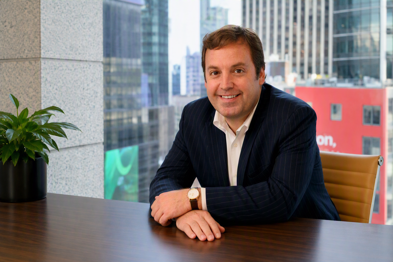 Man sitting at table wearing suit and smiling