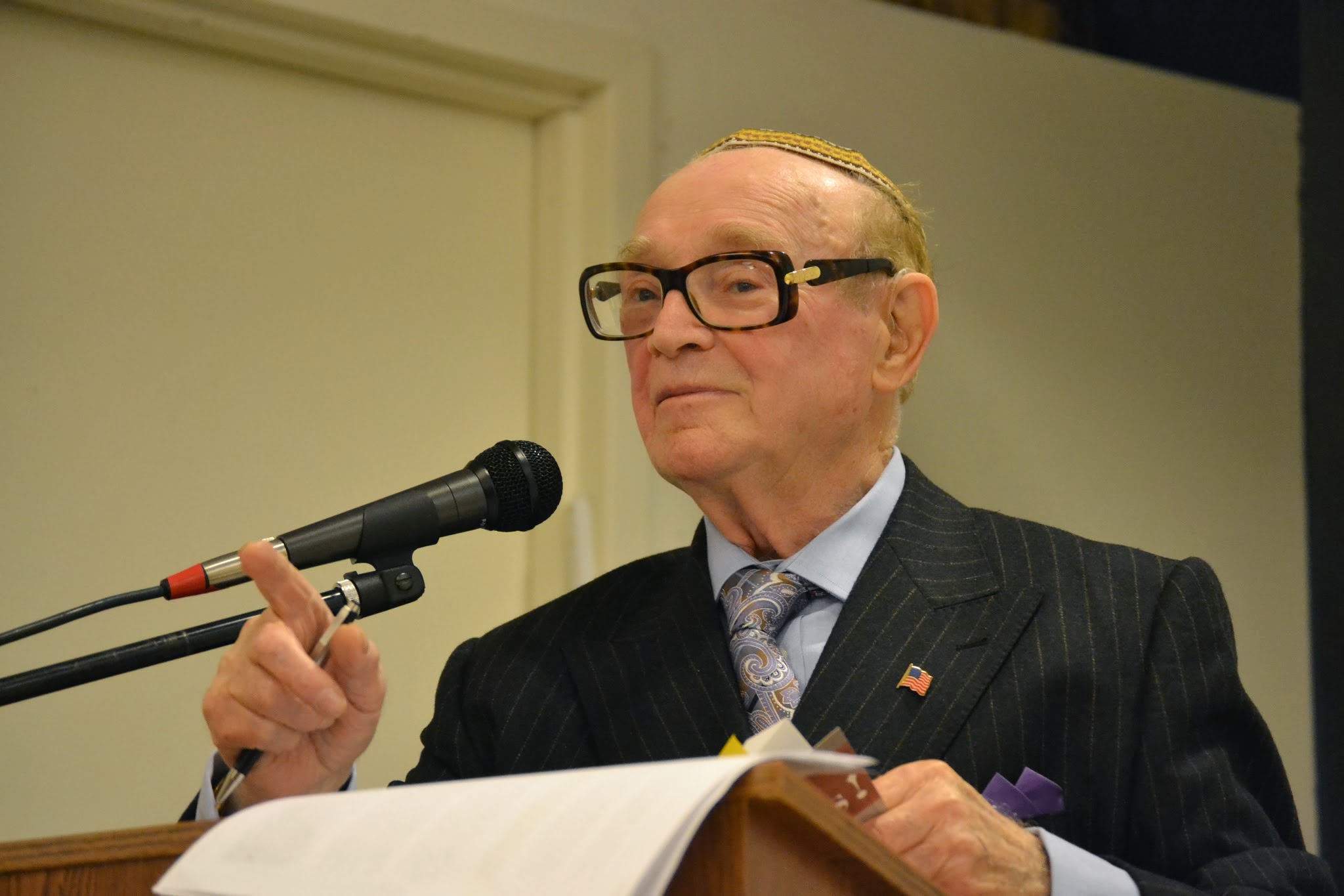 Mark Hasten addresses an audience of nearly 100 when Touro College commemorated the 75th anniversary of Kristallnacht. 