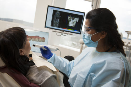 Touro College of Dental Medicine (TCDM) student (right) using an intraoral scanner to take digital impressions of her patient’s teeth.