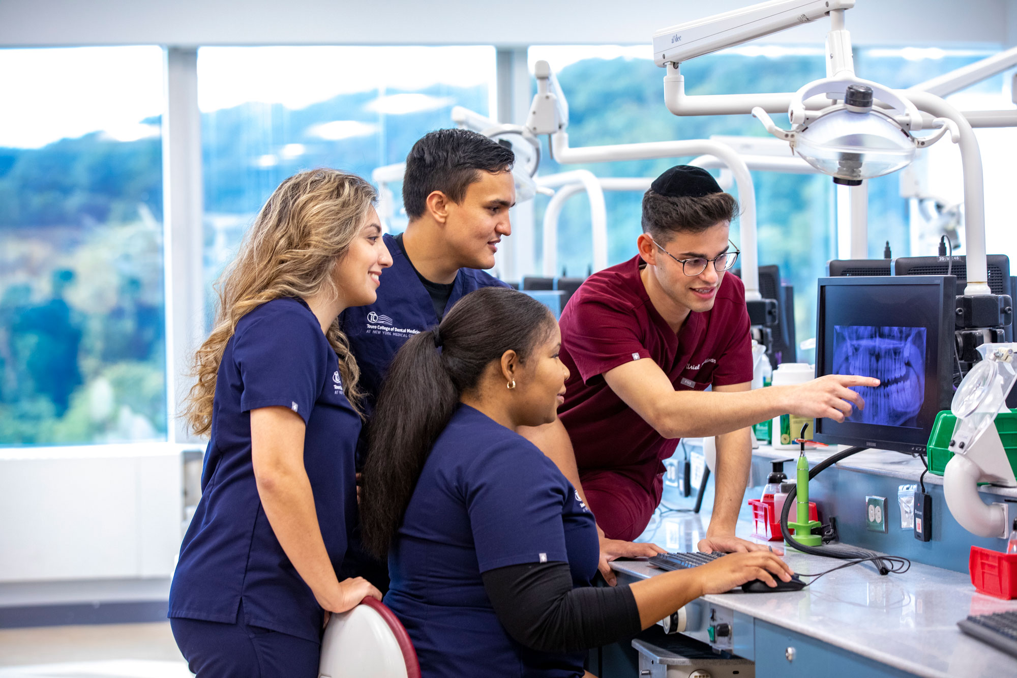 Four dental students looking at x-ray in lab