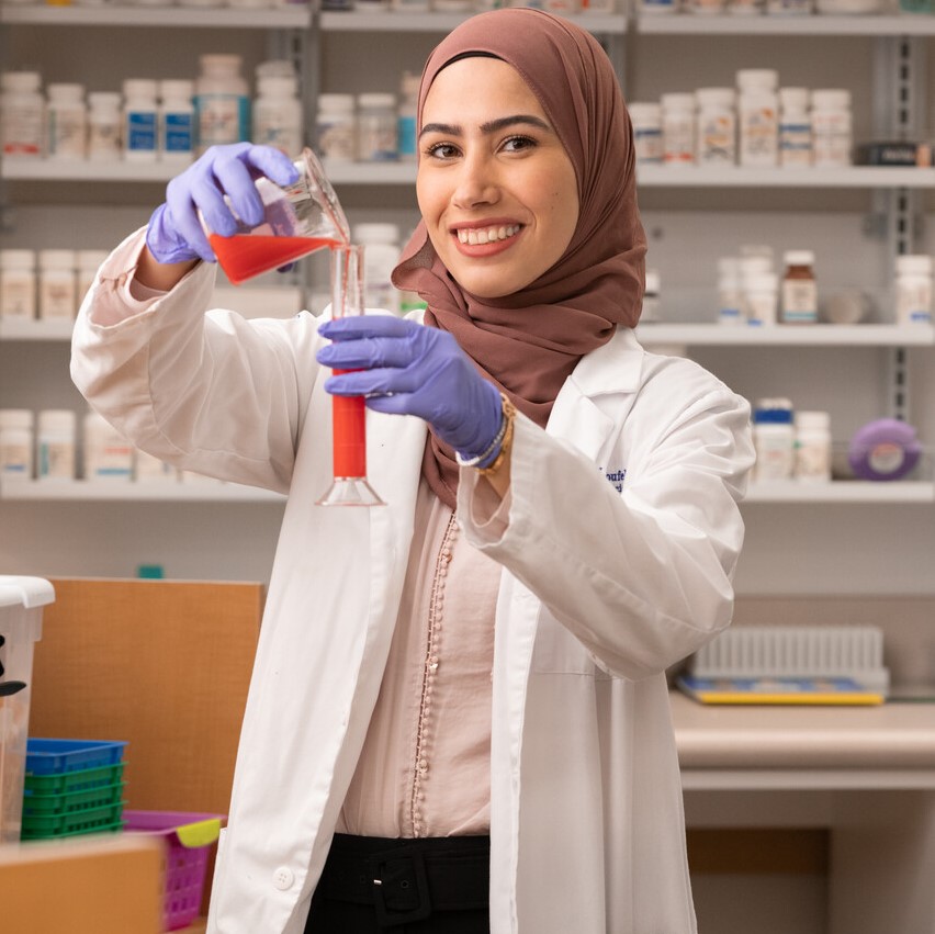 Pharmacy student in lab with beaker