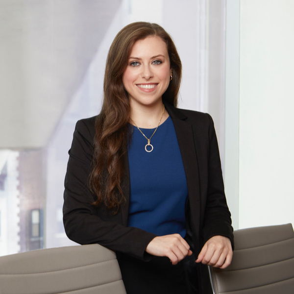 Naomi Perla standing in office in front of windows