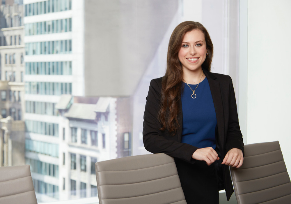 Naomi Perla standing in office in front of windows