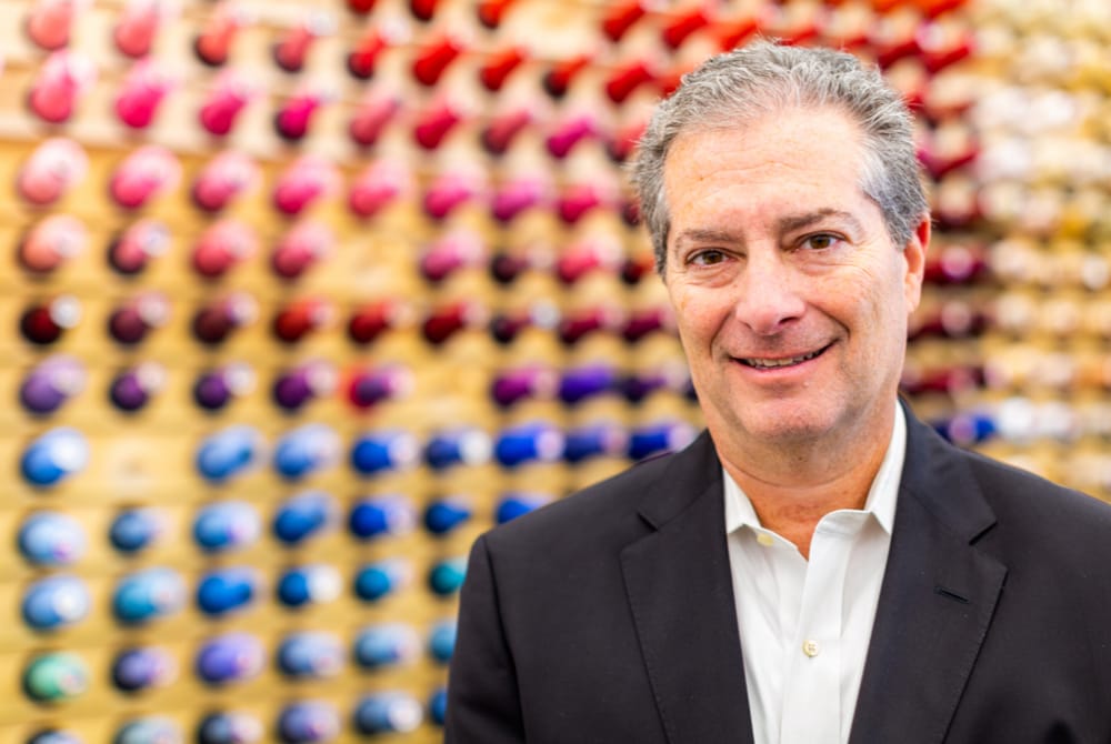 Todd Kahn in front of a rack of thread spools