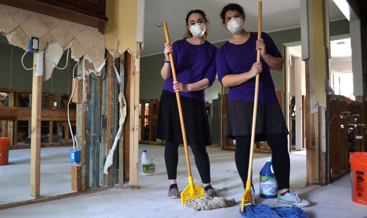 LCW students with mops inside a house in Houston